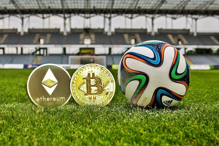 Coins crypto avec un ballon sur un terrain de football